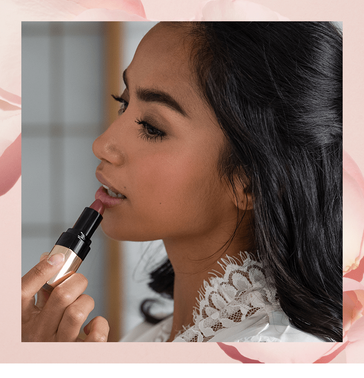 Imagine containing step 5 model applying lipstick, smiling while looking into compact Bobbi Brown mirror