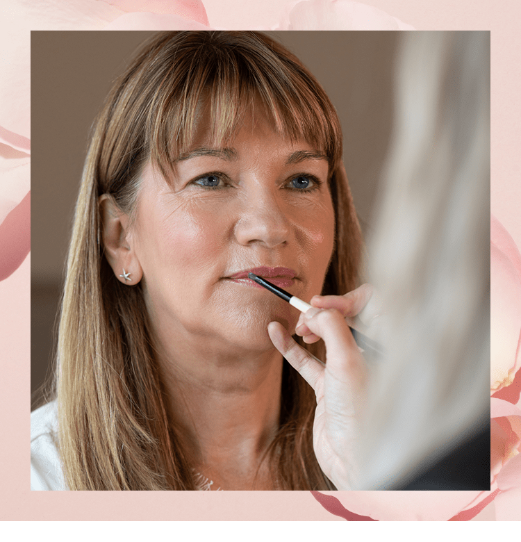Imagine containing step 5 model applying lipstick, smiling while looking into compact Bobbi Brown mirror