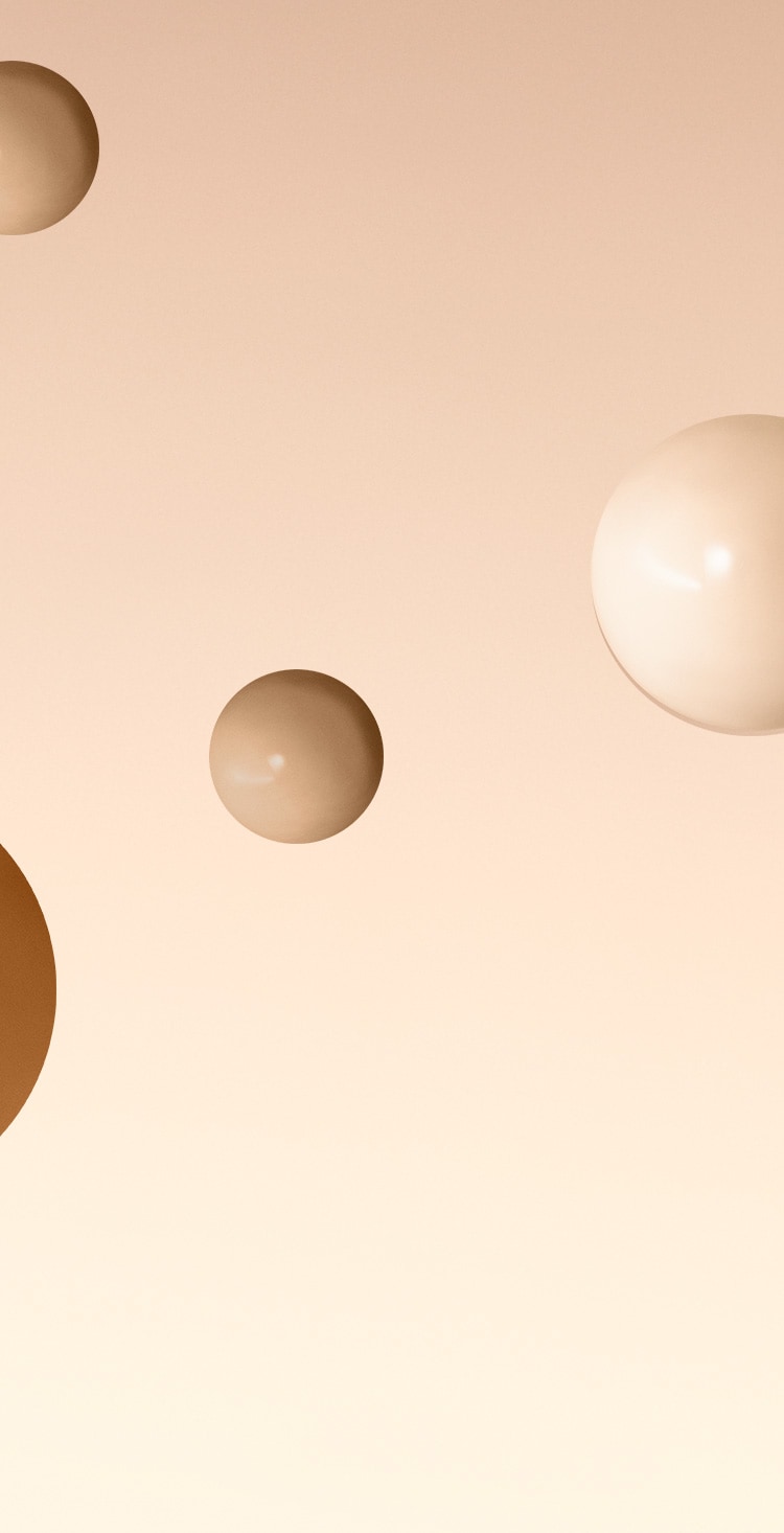 Background image containing skin-toned gradient with Vitamin Enriched Skin Tint foundation spheres floating