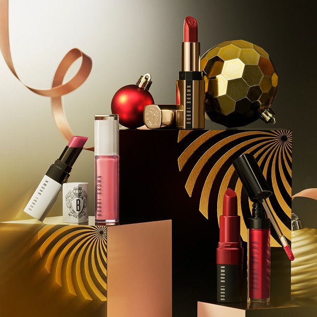 Close up of model applying Crushed-Oil Infused Gloss to lips